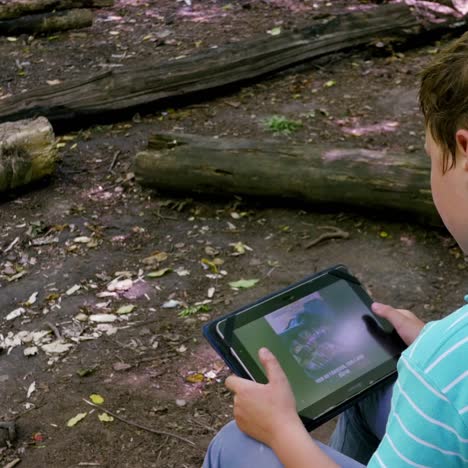 boy with tablet in the forest
