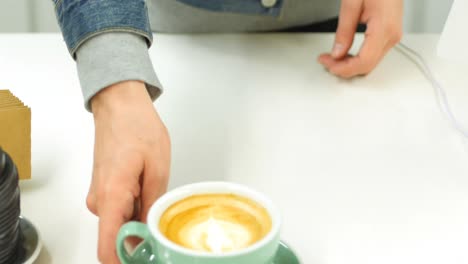 Mid-section-of-man-preparing-cup-of-coffee-in-kitchen