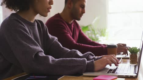 Side-view-of-two-colleagues-working-in-creative-office