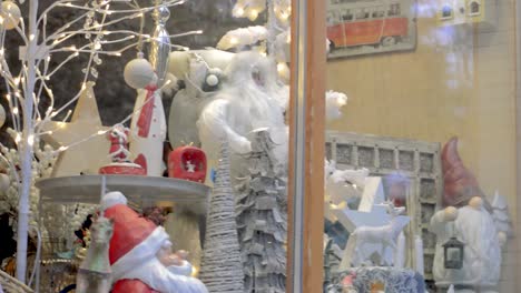 Santa-Claus,-Luces-Navideñas-Y-Decoraciones-Detrás-De-La-Ventana-De-La-Tienda-De-La-Ciudad