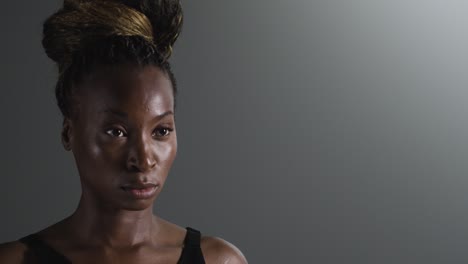 Studio-Shot-Of-Woman-Wearing-Gym-Fitness-Clothing-Putting-Up-Hair-Before-Exercise-1