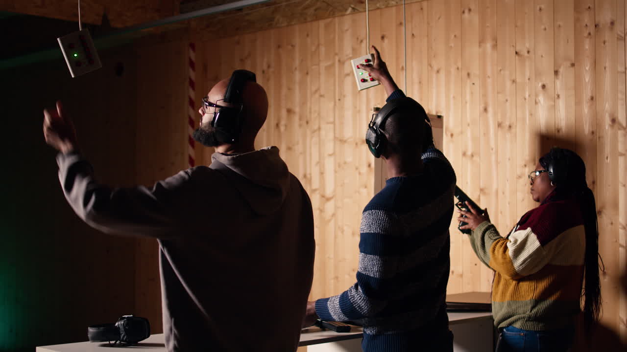 Friends in firing range doing shooting, pressing mechanism to recall targets
