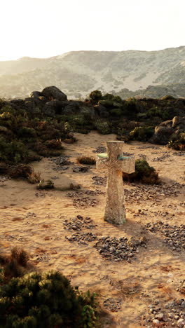 cruz de piedra en un paisaje desértico