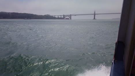 Toma-De-Cardán-De-Una-Gaviota-Cabalgando-Las-Corrientes-De-Viento-A-Lo-Largo-Del-Costado-De-Un-Bote-A-Medida-Que-Se-Acerca-Al-Puente-Golden-Gate-En-San-Francisco-En-La-Niebla