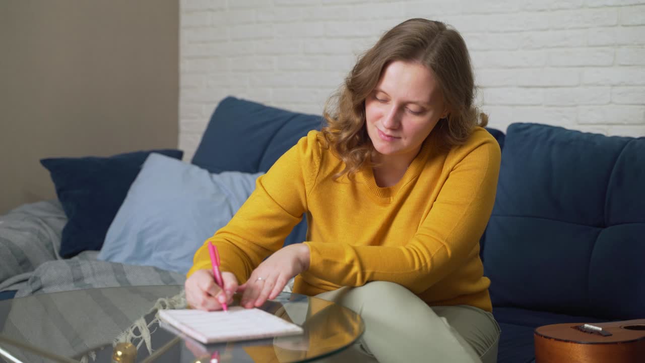 Donna che scrive su fogli di carta a un tavolo di vetro con una penna. Legge e corregge con la penna. Studiare, prepararsi per un discorso, controllare un contratto, formazione, lezione.