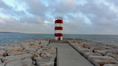 faro en un pontón y un cielo nublado