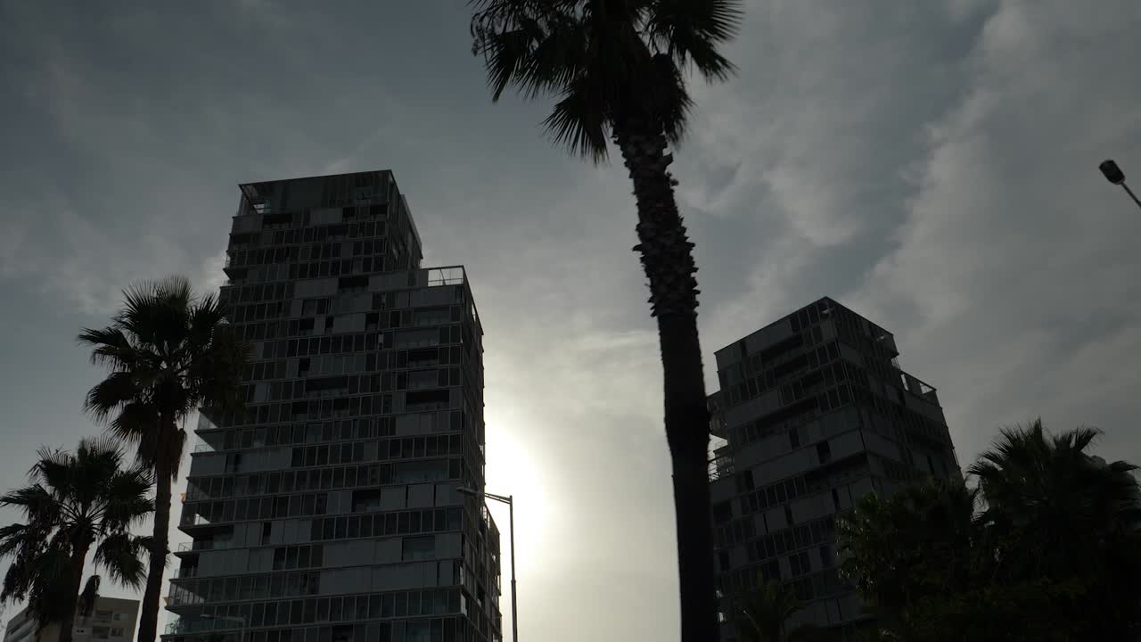 El sol poniéndose detrás de un edificio alto