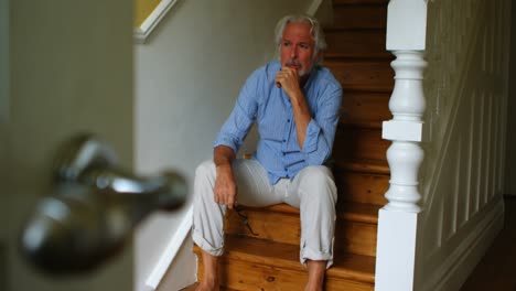 upset senior man sitting on stairs 4k