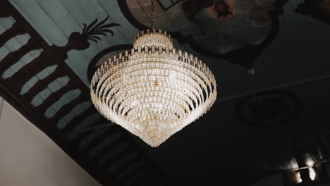 elegant chandelier with ceiling frescoes inside church