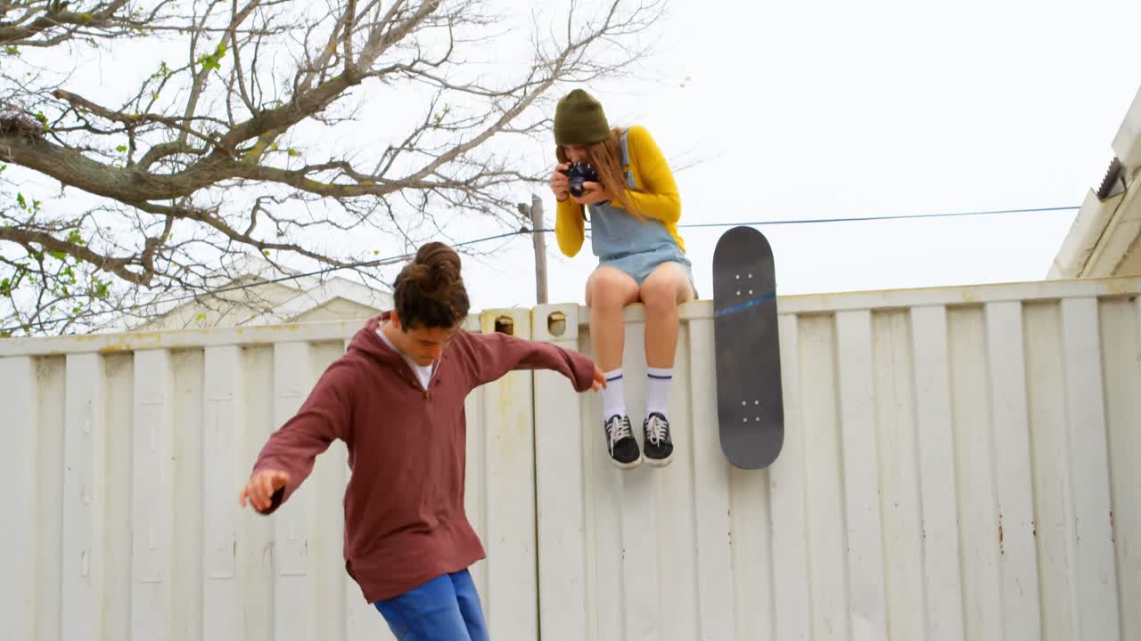 vista frontal de un joven caucásico haciendo un truco de skateboard en una rampa de skateboard en la cancha de skateboard 4k