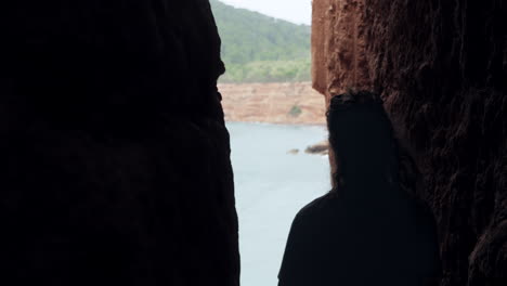 tourist walking through a narrow sea cave