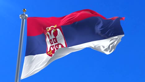 bandera de serbia ondeando en el viento en lento con cielo azul, bucle