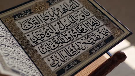 close-up, angled shot of an open quran, showcasing intricate arabic calligraphy, ideal for a video