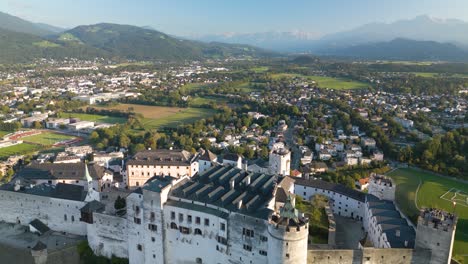 drone flies over hohensalzburg fortress at sunset in salzburg, austria