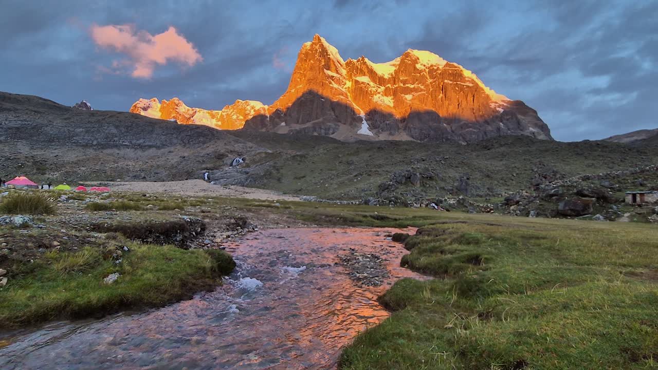 Nature background: Golden hour mountain peak with alpine meadow stream