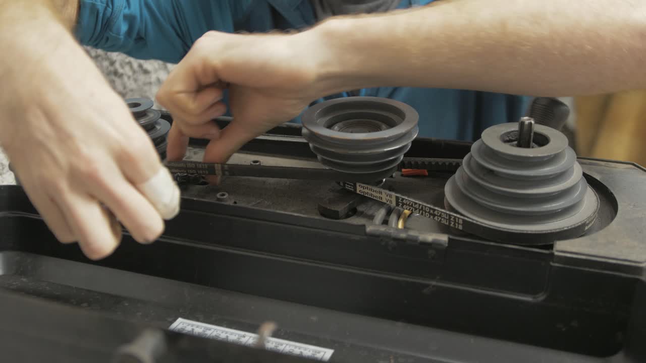 래칫으로 기둥 드릴을 조정하는 장인. 미디엄 샷