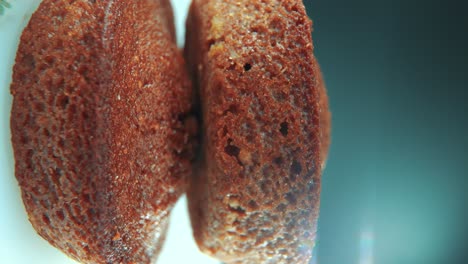 a vertical macro close up shot of tasty cupcakes, on a 360 rotating stand, white plate, studio lighting, slow motion, smooth movement, 4k video