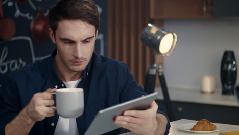 Portrait-of-focused-business-man-using-tablet-computer-at-home-office.