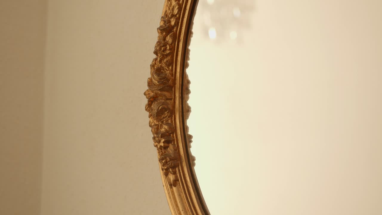 Dettaglio di uno specchio vintage con cornice dorata appeso al muro