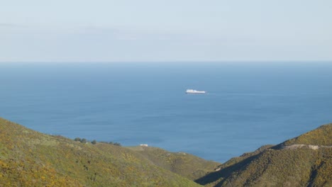 Eine-Fähre,-Die-Im-Ruhigen-Ozean-Segelt,-Mit-Landschaft-Im-Vordergrund