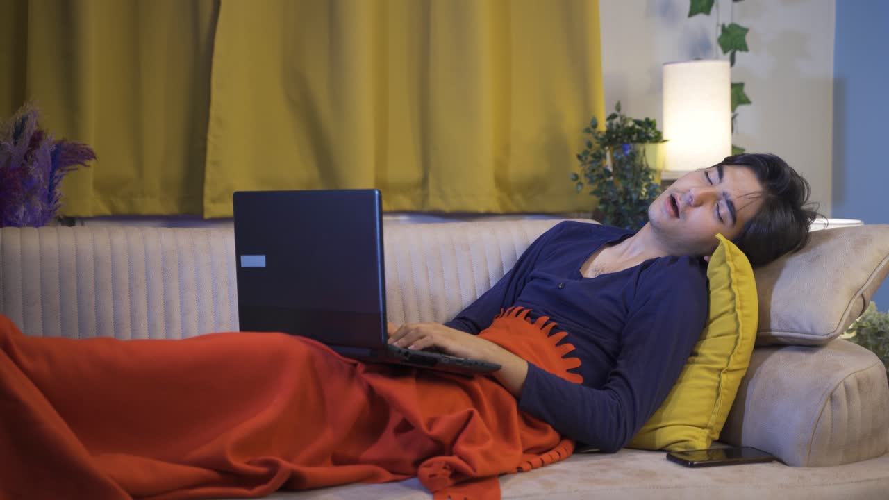 el hombre que usa la computadora portátil acostado se queda dormido.