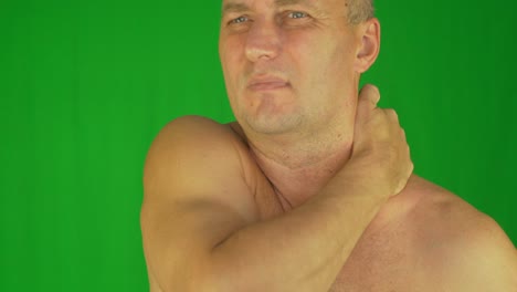 un primer plano extremo de un hombre frotándose el cuello y los hombros.