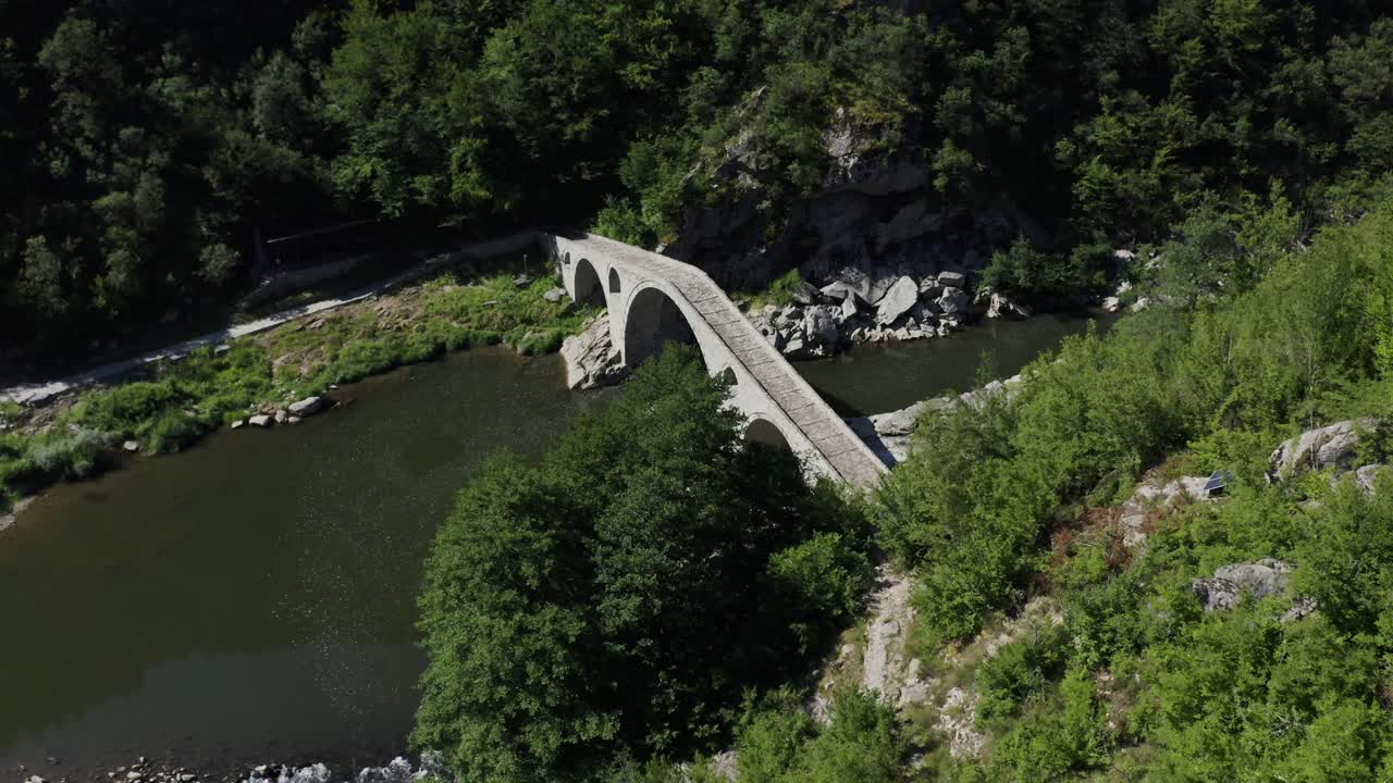 Approaching drone shot with a view from above of the Devil's Bridge and Arda River located near the town of Ardino at the foot of the Rhodope Mountains in Bulgaria