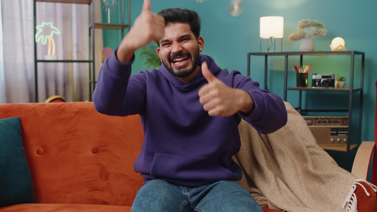 Happy indian man looking approvingly at camera showing thumbs up like positive sign good news