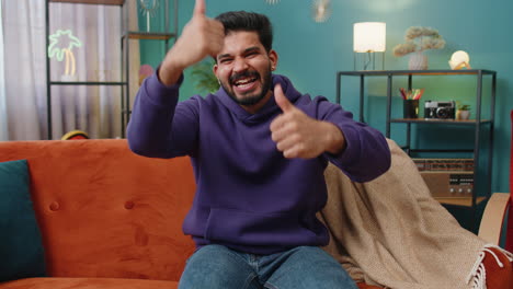 happy indian man looking approvingly at camera showing thumbs up like positive sign good news