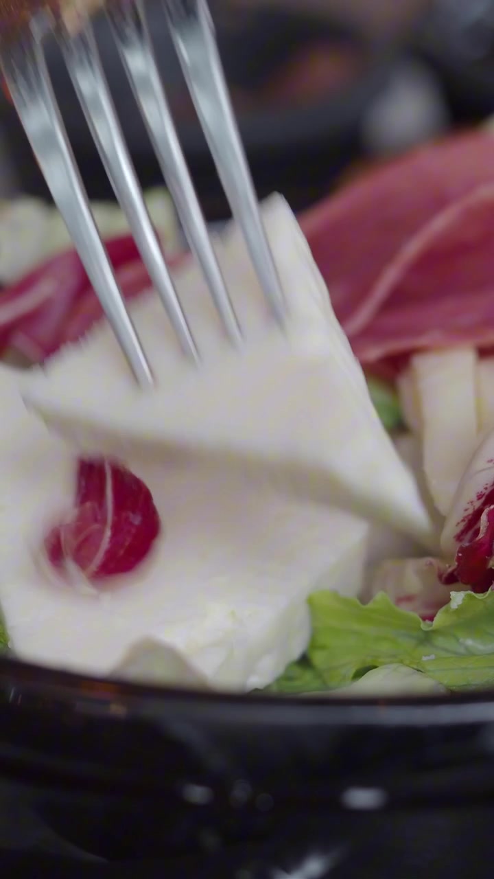 Detail vidličky nabírající sýr feta z čerstvého salátu