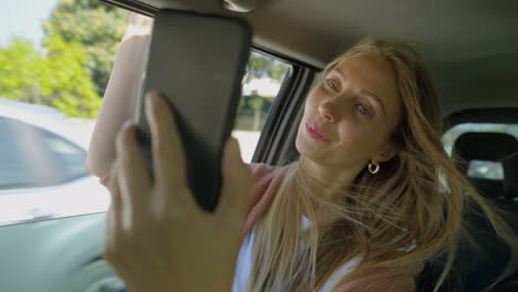 happy girl taking selfie in car