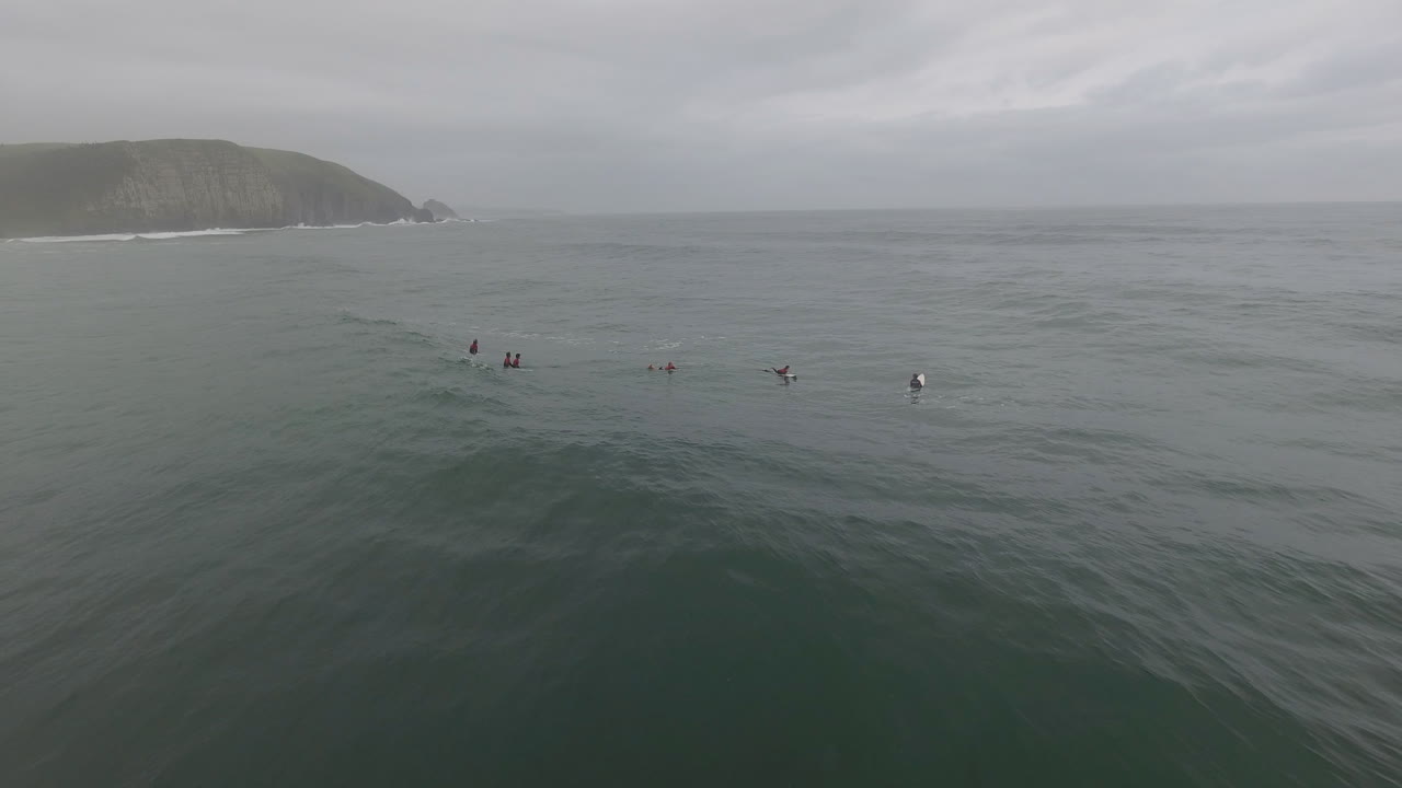 남아프리카 공화국의 커피 베이에서 서핑하는 서퍼 위로 날아가는 공중 액션 시네마틱
