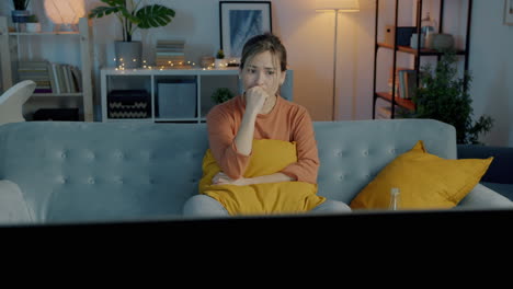 woman watching tv, showing emotional distress
