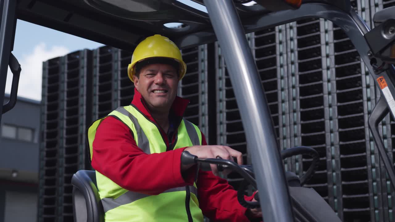 Warehouse worker driving forklift outside factory