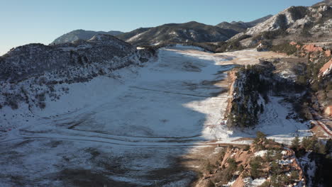 Aerial-fly-over-snow-covered-valley-in-the-mountains-on-sunny-day