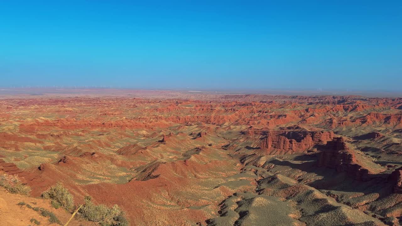 Pingshan Lake Grand Canyon, Zhangye, provincia di Gansu, Cina - Una vasta distesa di crinali di roccia rossa stratificata si apre attraverso il deserto sotto un cielo azzurro limpido - Panoramica a destra