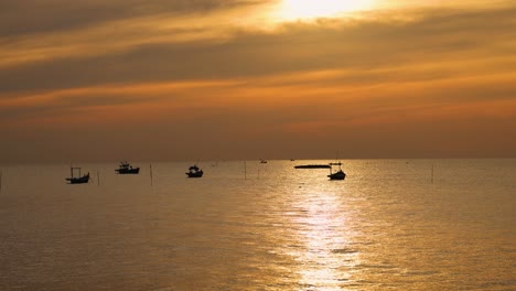 boats silhouetted against a vibrant sunset sky