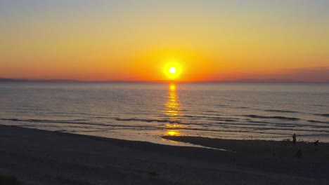 Aéreo-Drone-Mosca-Amanecer-Horizonte-Dorado-Sol-Brillar-Encima-Playa-Arenoso-Agua-Orilla-Findhorn-Escocia