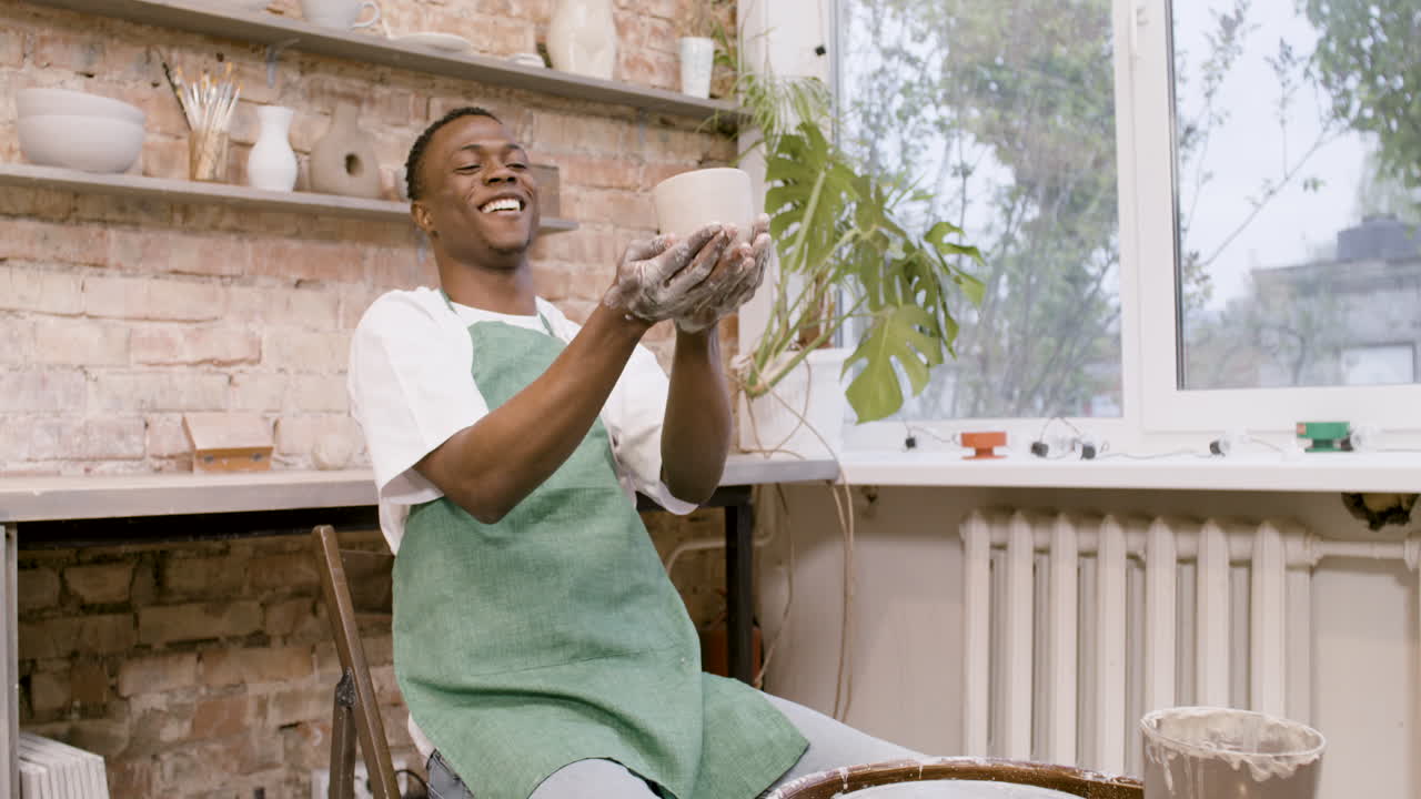 American Clerk Looking At A Ceramic Piece That He Has Modeled On The Potter Wheel