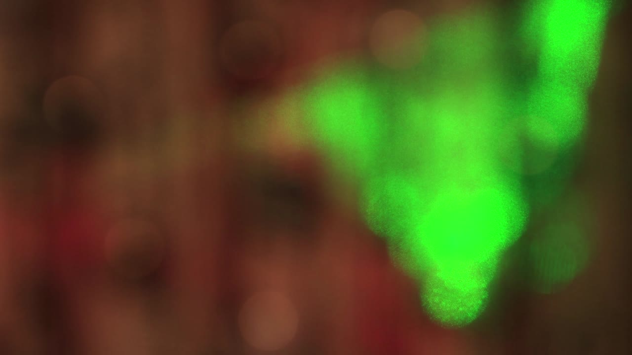 Luci bianche delicate e festive nell'oscurità e un raggio verde e rosso che si muove lentamente.