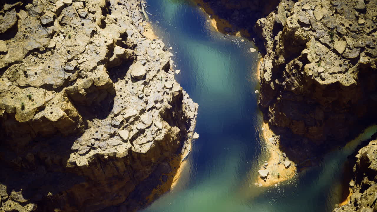 Serene river winding through rocky terrain at midday in a remote area