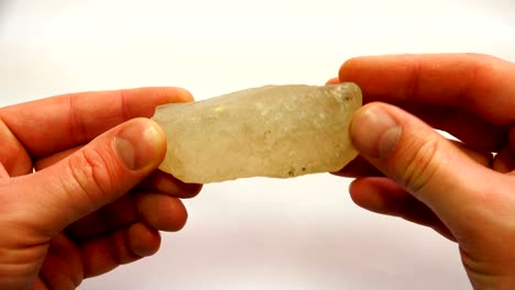un mineral transparente en las manos de un geólogo
