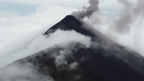 drone video of an active volcano half covered by clouds in antigua, guatemala