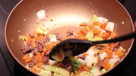 mezclar carne de res y verduras en una sartén