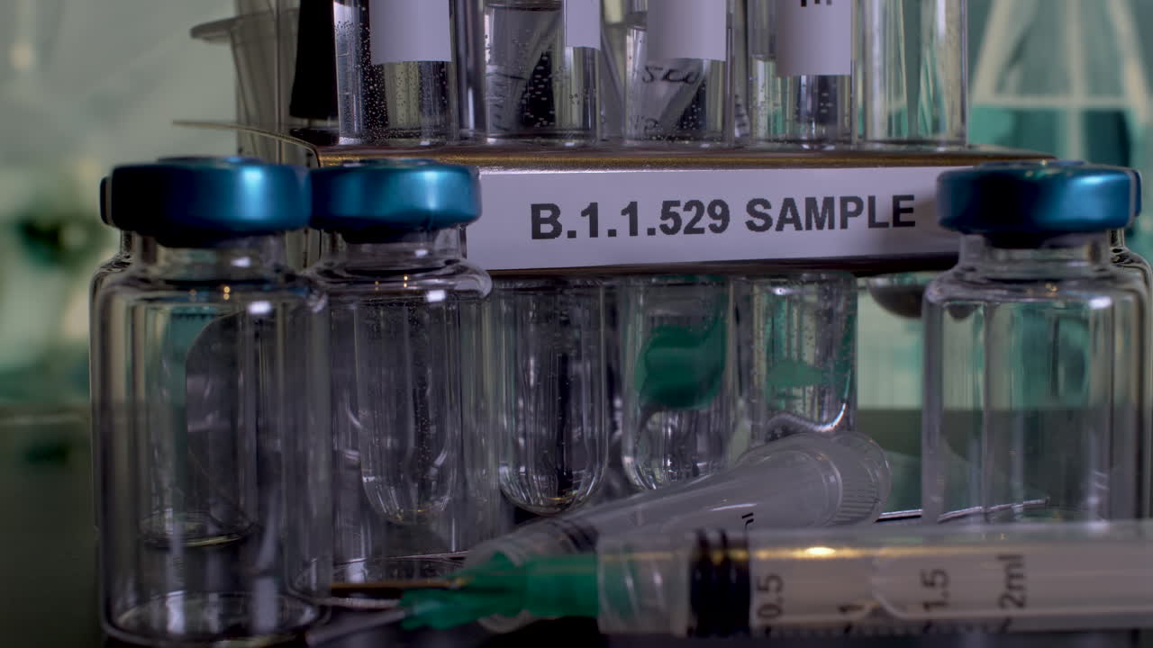 B.1.1.529 Sample Test Tubes Being Placed Into Rack Next To Empty Vial Bottles And Syringes. Static, Close Up