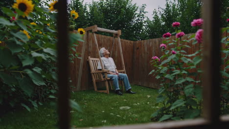 senior man relaxing in a garden swing