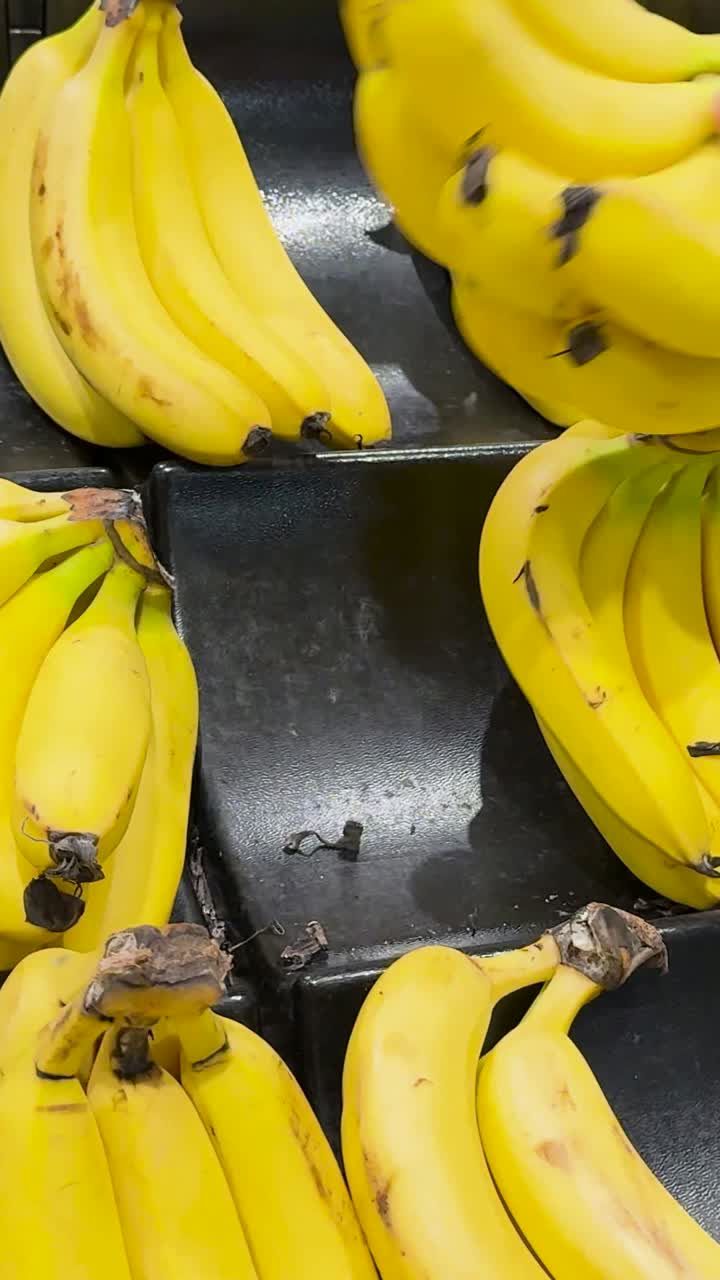 una mano recoge plátanos de una exhibición