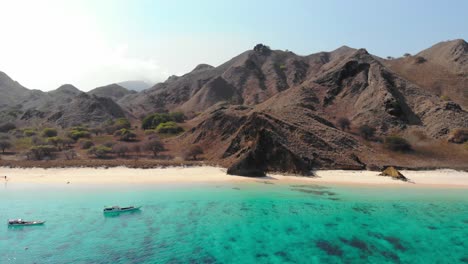 turquoise water and steep rugged hills of pantai merah on padar island in komodo national park, indonesia