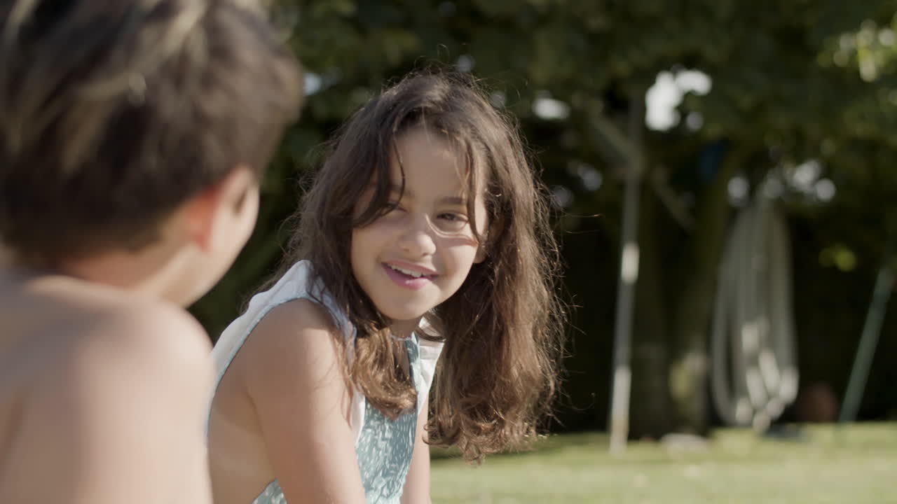 여름날에 행복하게 대화하는 두 아이의 클로즈업 측면 시각.
