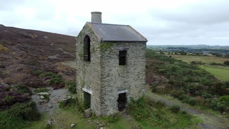 parys mountain abandoned brick chimney copper mining mill stone ruin aerial view low orbit left